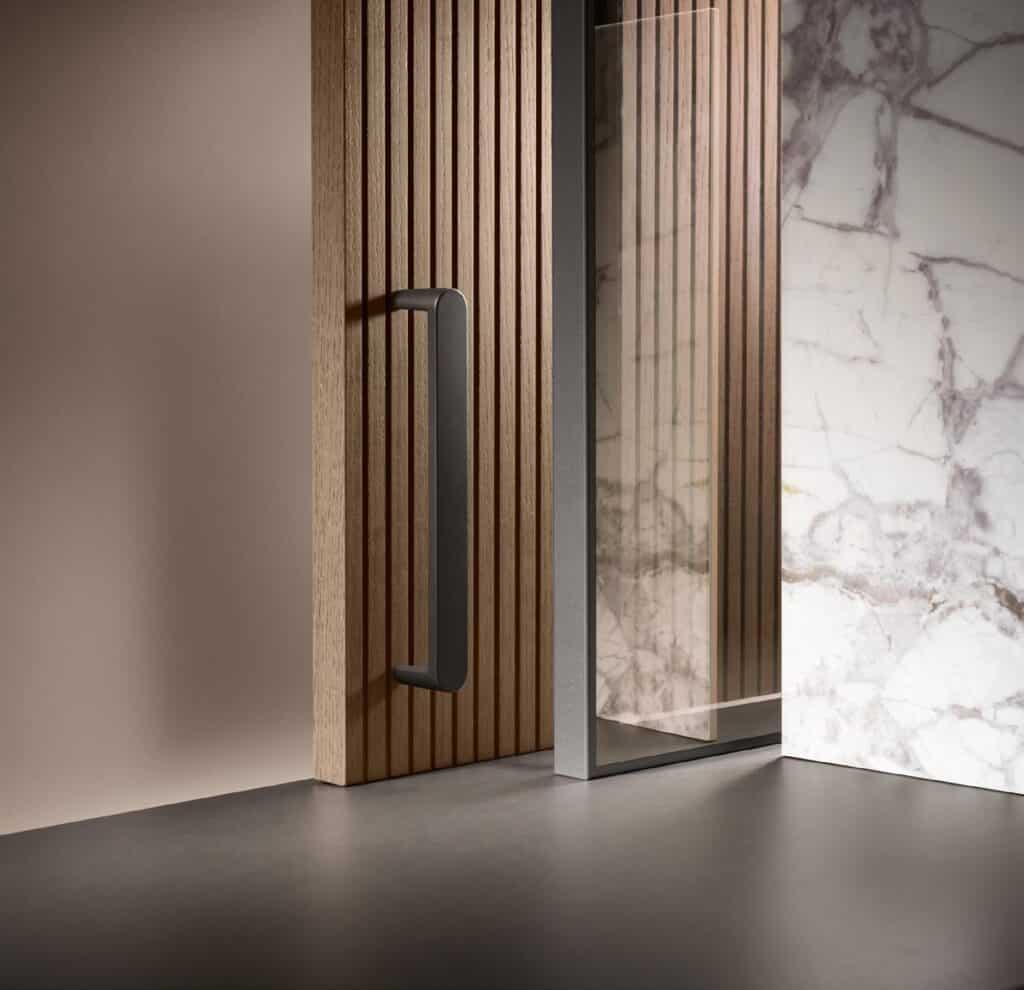 Wooden slatted panel with a metal handle next to a marble surface.