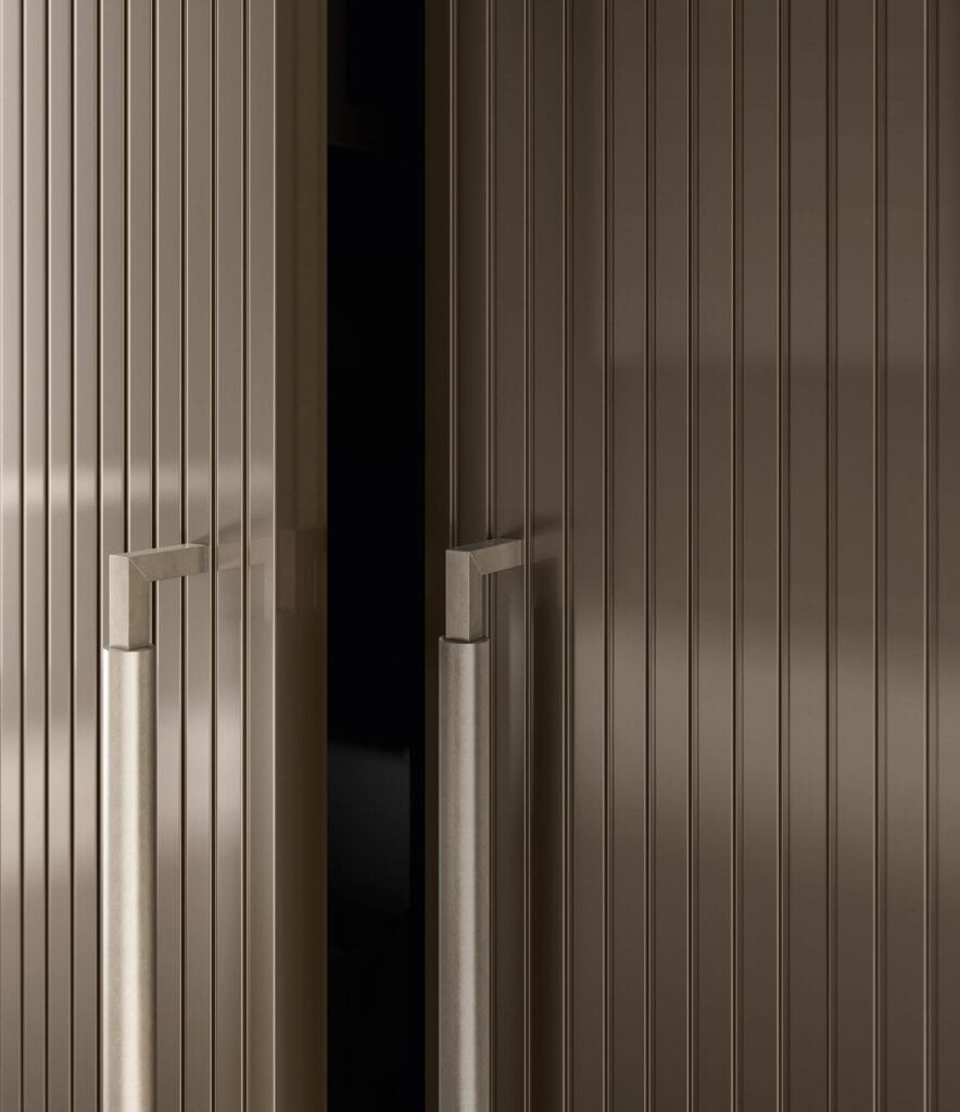 Close-up of partially open, vertically grooved cabinet doors with modern metal handles.