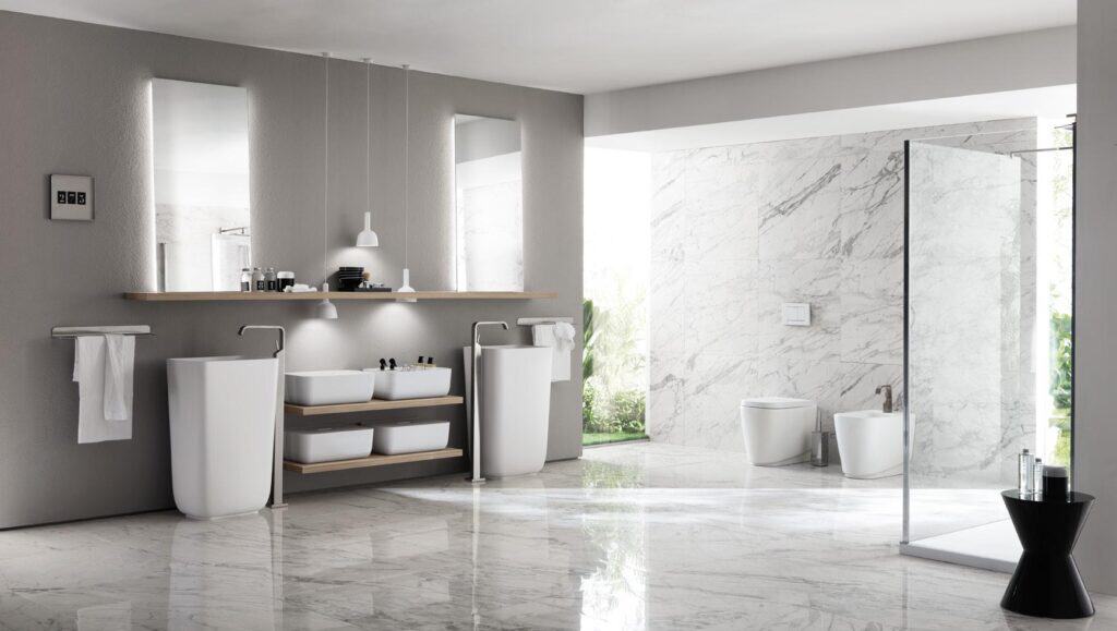 Modern bathroom with freestanding sinks, marble floors, and a large glass shower enclosure.