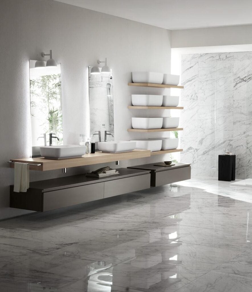 Modern bathroom with double sinks, wall-mounted mirrors, and marble flooring.