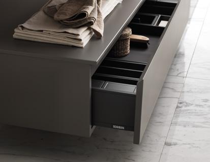 Open drawer of a modern cabinet with organized compartments and items inside.