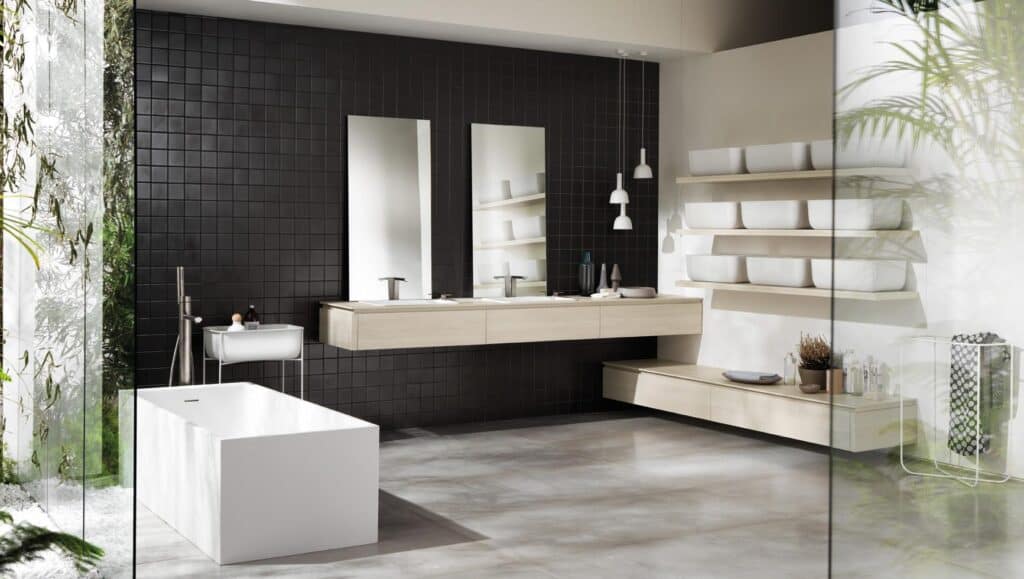Modern bathroom with black tiled wall, two mirrors, floating vanity with two sinks, freestanding bathtub, and open shelves.