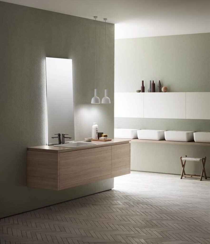 Modern bathroom interior with a floating wooden vanity, a large mirror, pendant lights, and minimalist shelves with decorative vases.