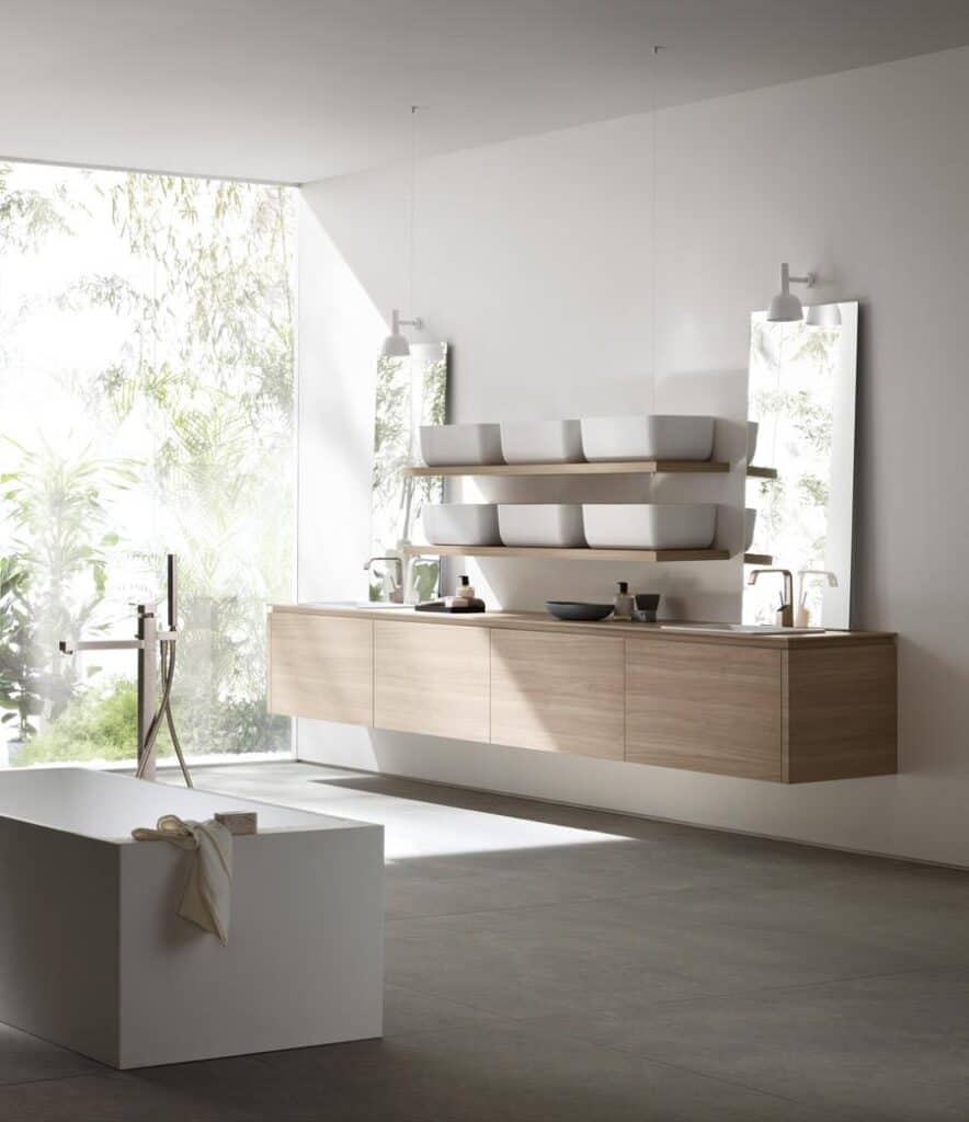 Minimalist bathroom with large windows, a floating wooden vanity, mirrors, and modern white fixtures.