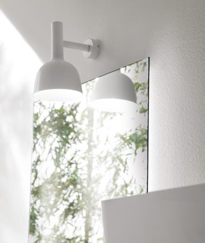 White wall-mounted lamp reflecting on a mirror.