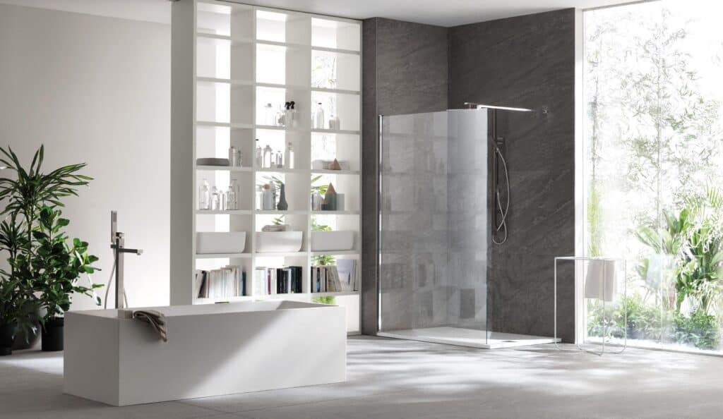 Modern bathroom with a freestanding bathtub, glass shower, shelving unit, and large window with a view of greenery.