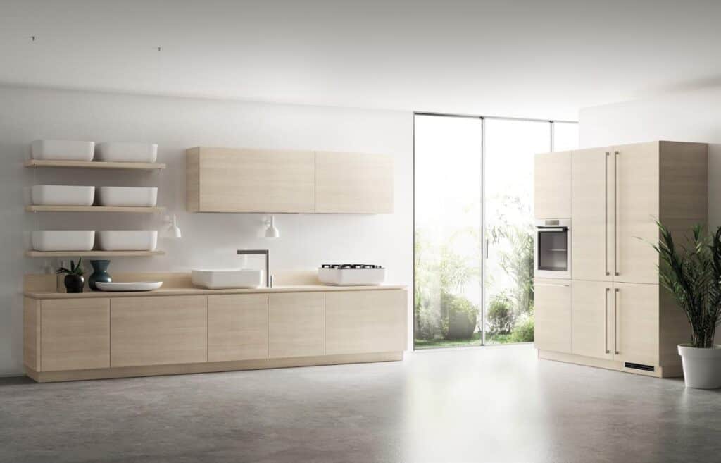 Modern minimalist kitchen with light wood cabinets, open shelving with white bowls, a sink, stove, and oven, large windows, and potted plants.