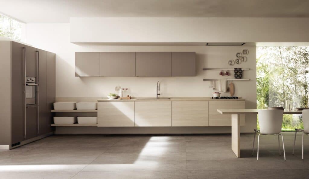 Modern kitchen interior with minimalist design featuring sleek cabinets, built-in appliances, a dining table with chairs, and large windows offering natural light.