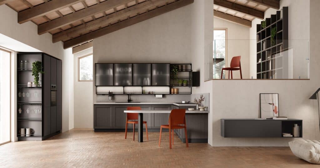 Modern kitchen and living space with dark cabinetry, open shelving, red chairs, and neutral flooring under a vaulted wooden ceiling.