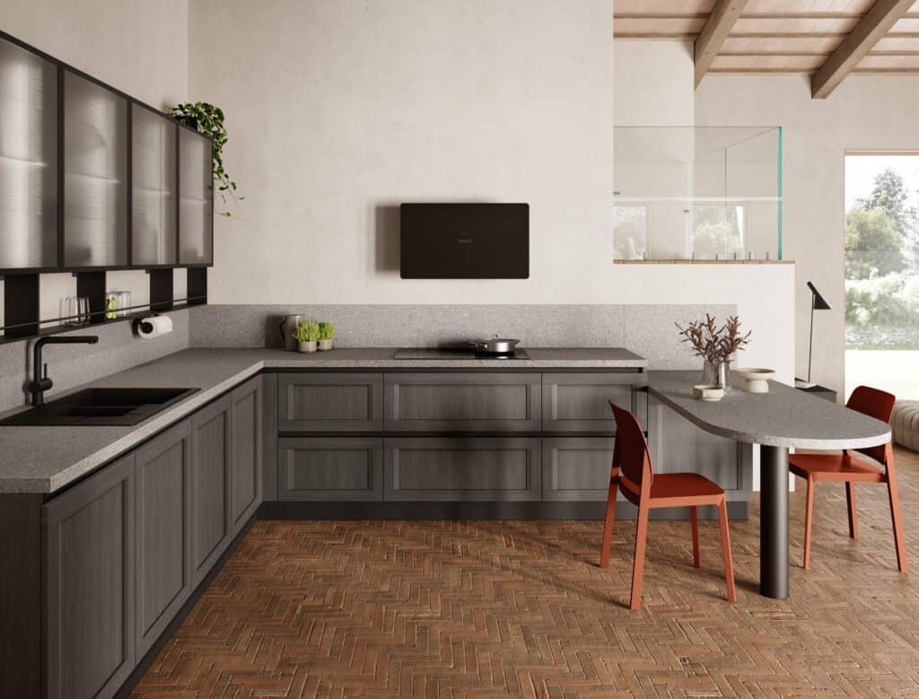 Modern kitchen with dark wood cabinetry, gray countertops, and integrated dining area. Features red chairs, herringbone wood flooring, and a plant on a wall cabinet.