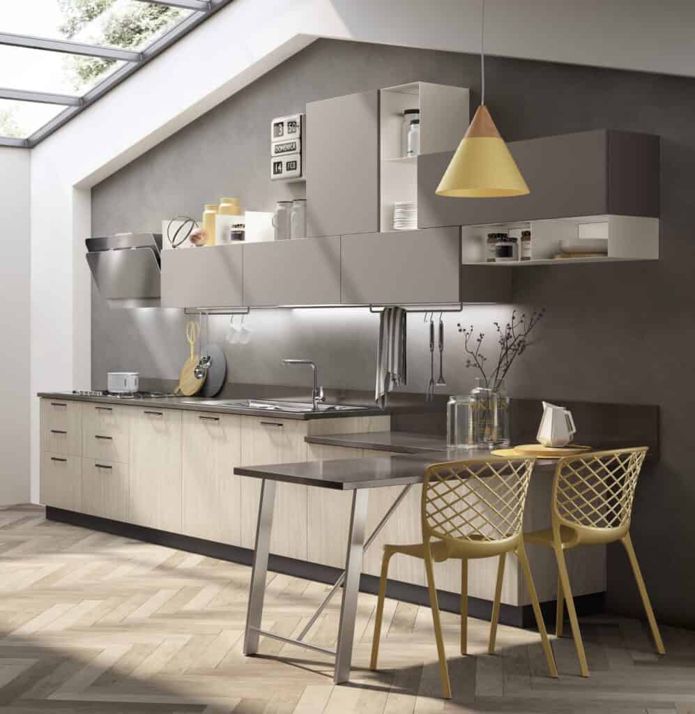 Modern kitchen with light wood cabinetry, floating shelves, black countertop, large pendant light, and yellow chairs under skylights.