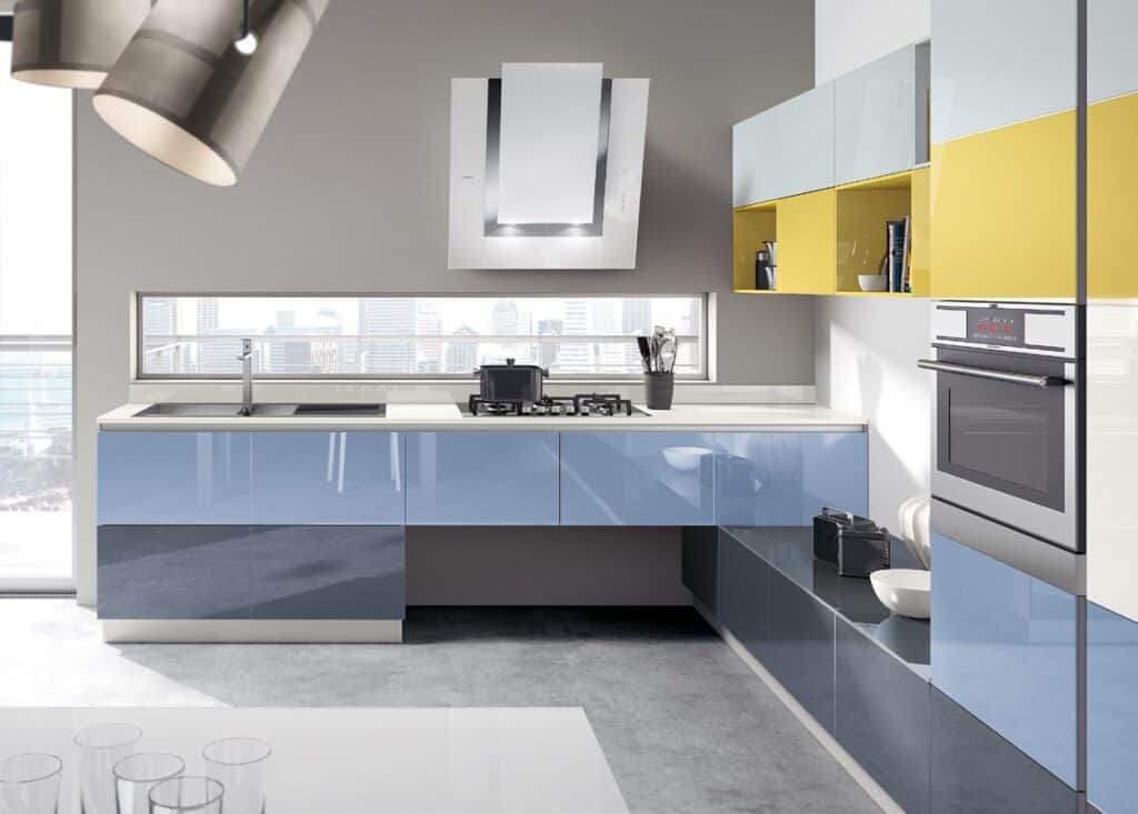 Modern kitchen with glossy blue cabinets, yellow upper shelves, built-in oven, and a sleek range hood.