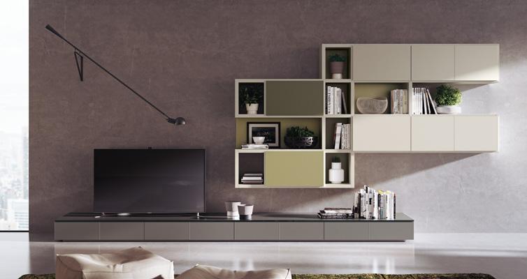Modern living room with a minimalist wall-mounted entertainment unit, featuring a large flat-screen TV and geometric shelves holding books and decor items against a gray wall.