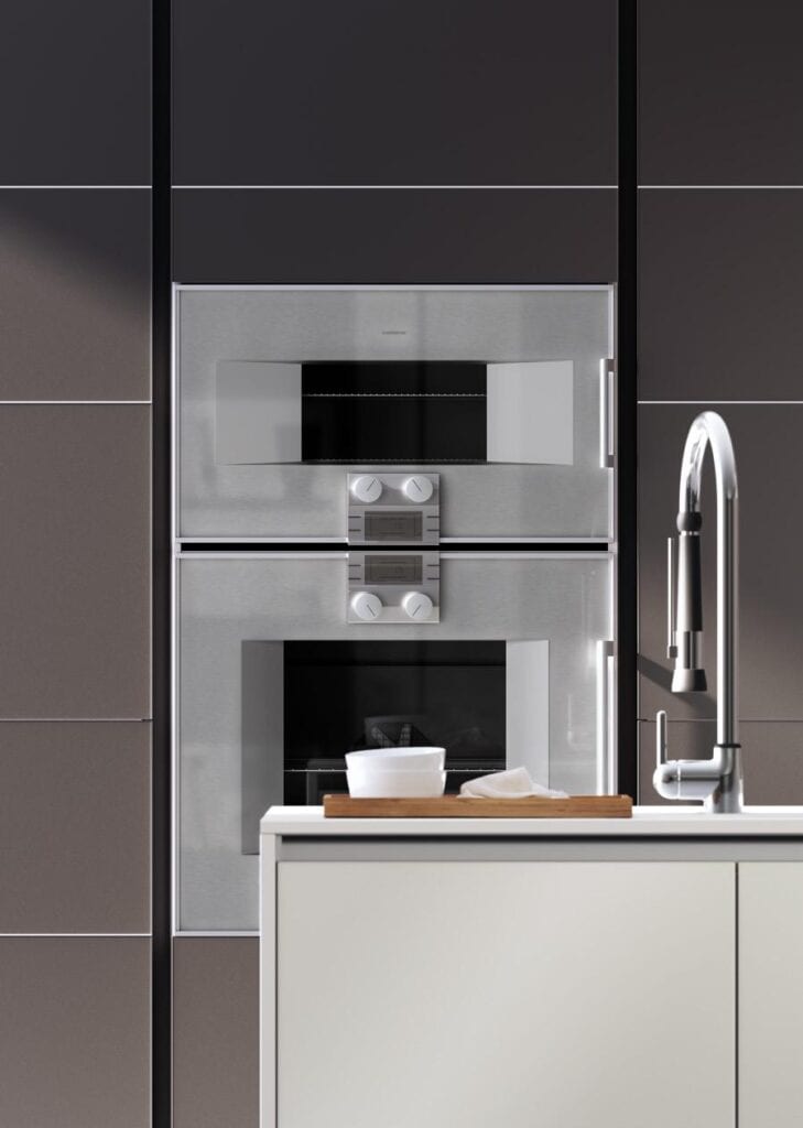 Modern kitchen with built-in oven and microwave, faucet, and countertop.
