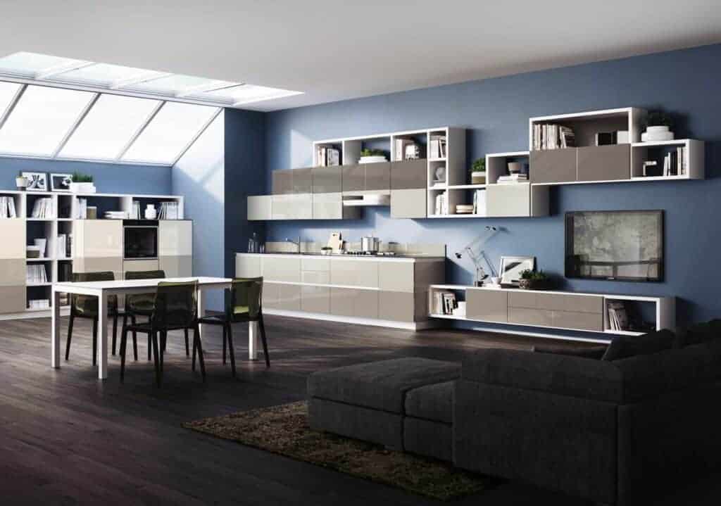 Modern kitchen and living room with blue walls, modular shelving, dark wood flooring, and a skylight.