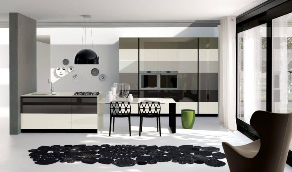 Modern kitchen with sleek cabinetry, black and white color scheme, pendant light, and decorative plates on the wall.