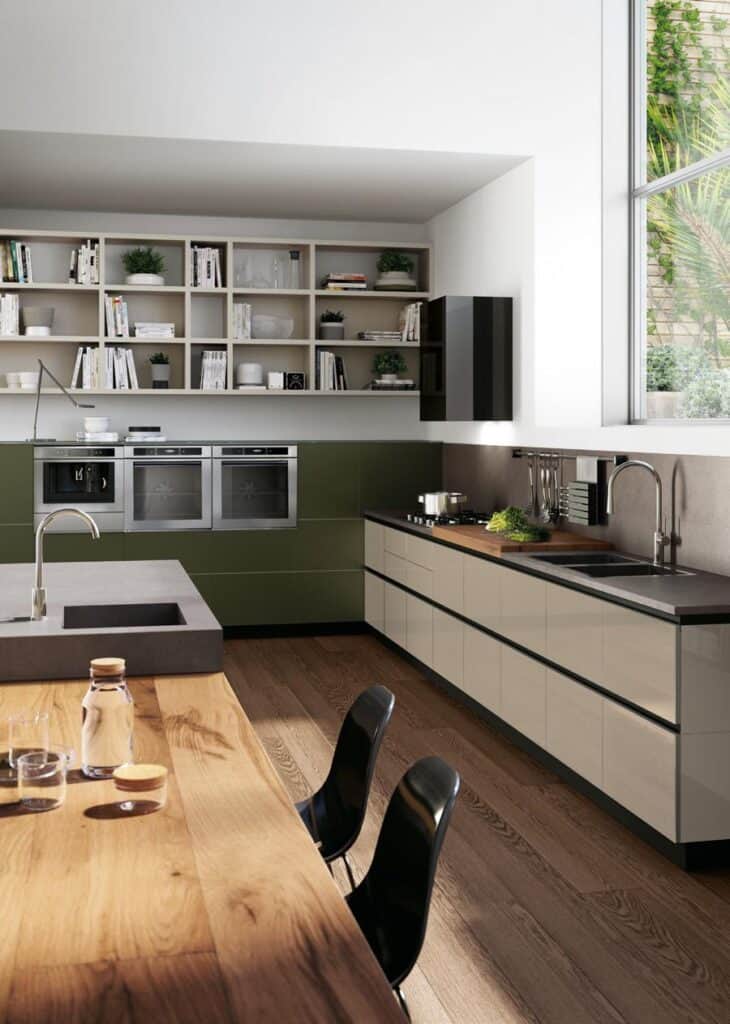 Modern kitchen with a wooden floor, sleek cabinetry, built-in ovens, open shelving with books and plants, a large window, and a wooden dining table with black chairs.