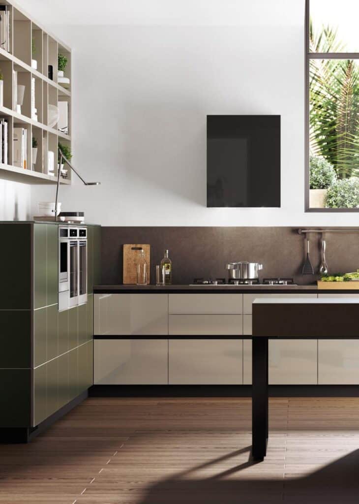 Modern kitchen with olive green and white cabinetry, stainless steel appliances, a countertop with cooking utensils, and a large window showcasing outdoor greenery.
