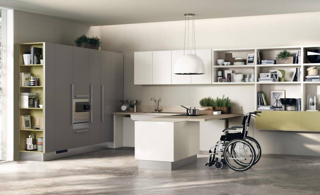 Modern kitchen with a wheelchair-accessible design, featuring sleek cabinets, open shelving, hanging lamp, and an empty wheelchair near the counter.