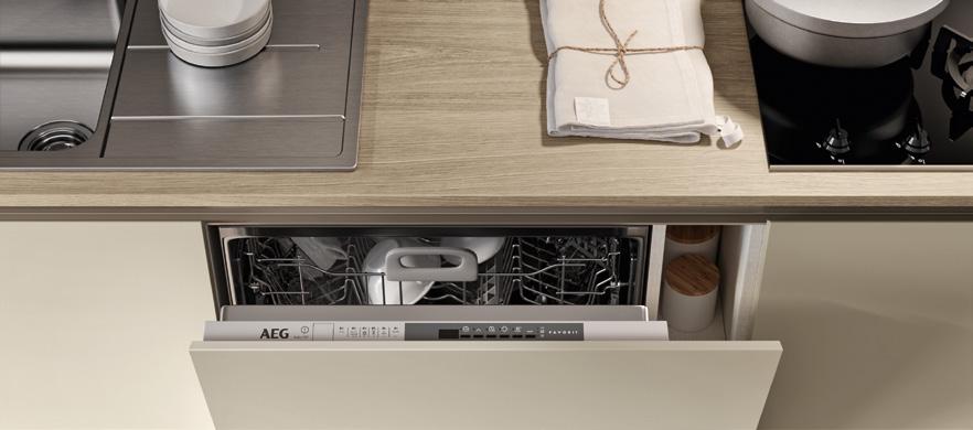 Open dishwasher with a top control panel beneath a wooden countertop in a modern kitchen.
