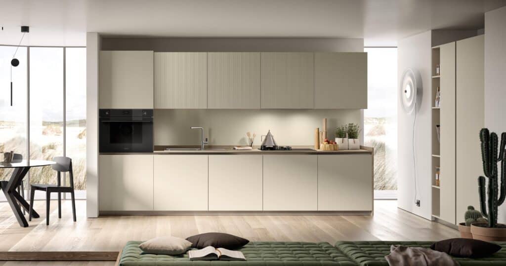 Modern kitchen with light cabinetry, built-in oven, countertop with sink and stove, a dining table with chairs, wooden flooring, and a large window.