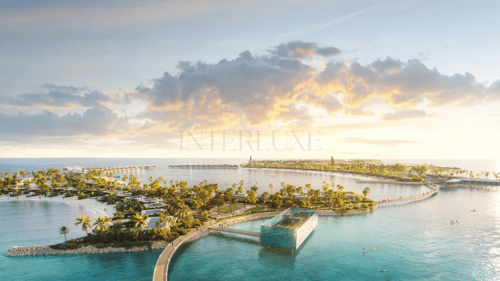 Aerial view of Interluxe Realty's luxury beachfront resort featuring villas, pools, and stunning ocean scenery.