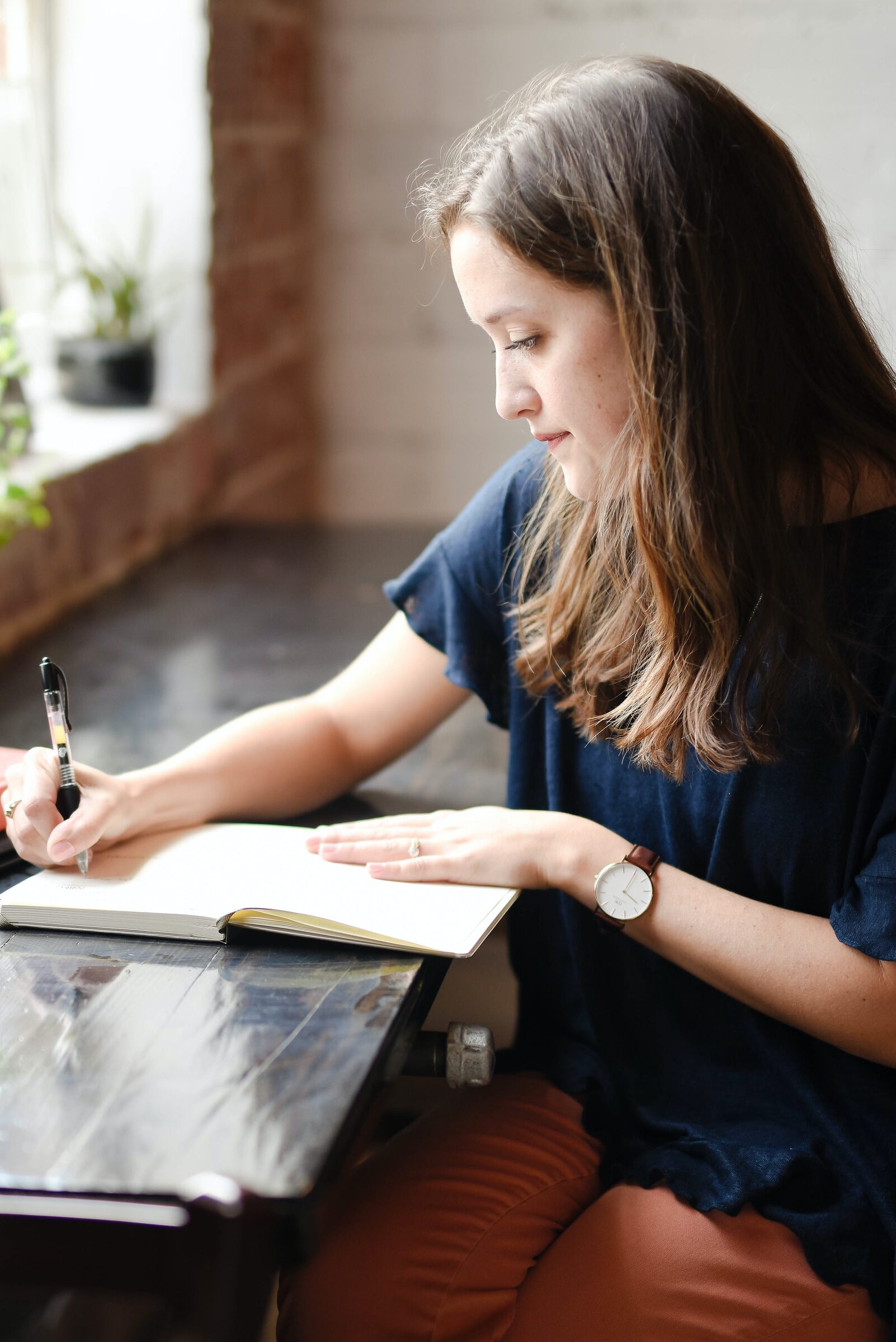 Woman sitting at desk writing in notebook