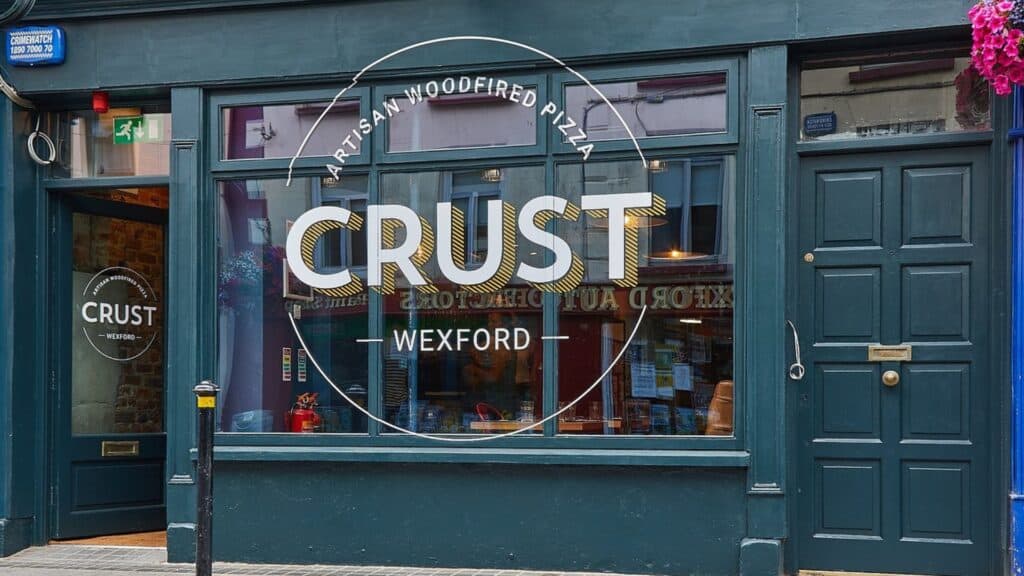 Handcrafted pizza restaurant's storefront with a teal exterior in Wexford, Ireland.