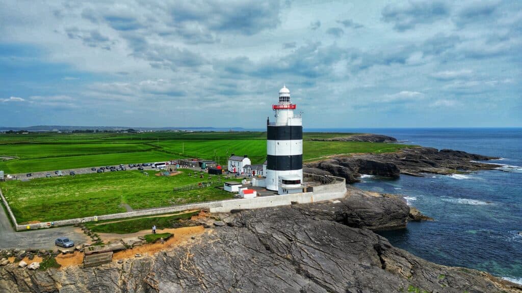 A breathtaking aerial view of Hook Lighthouse, nestled by the rugged Irish coastline.