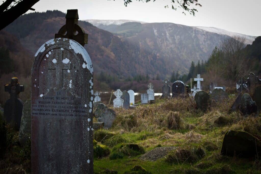 Scenic view of historic cemetery in Glendalough, surrounded by mountains and nature.