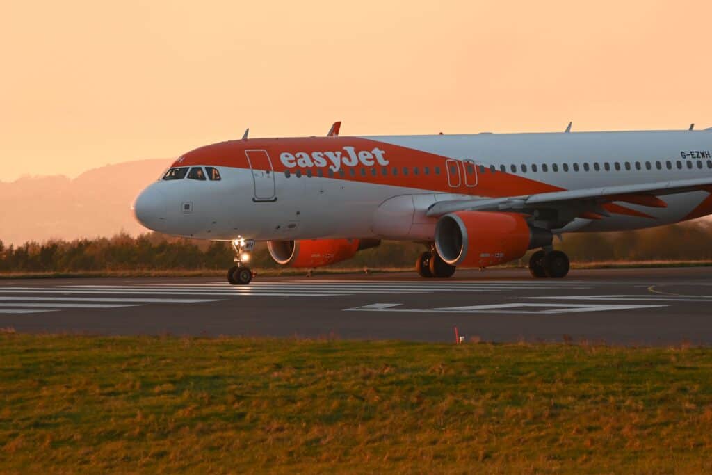EasyJet airplane taxiing on the runway during a vibrant sunset.