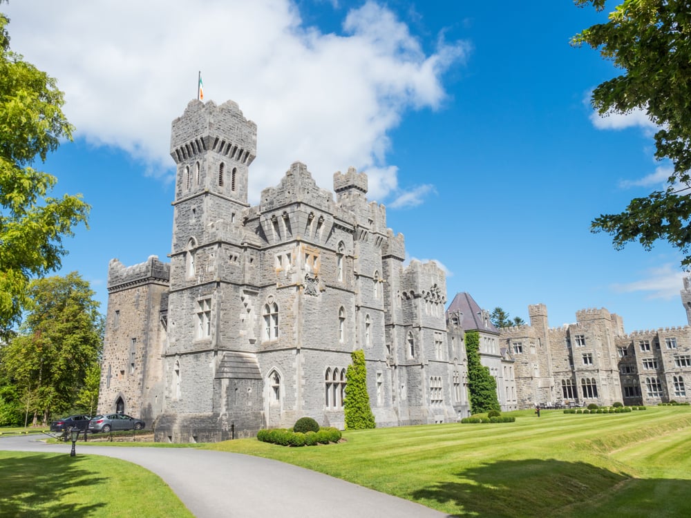 Blarney Castle in County Cork, Ireland, with lush green grounds and bluesky.