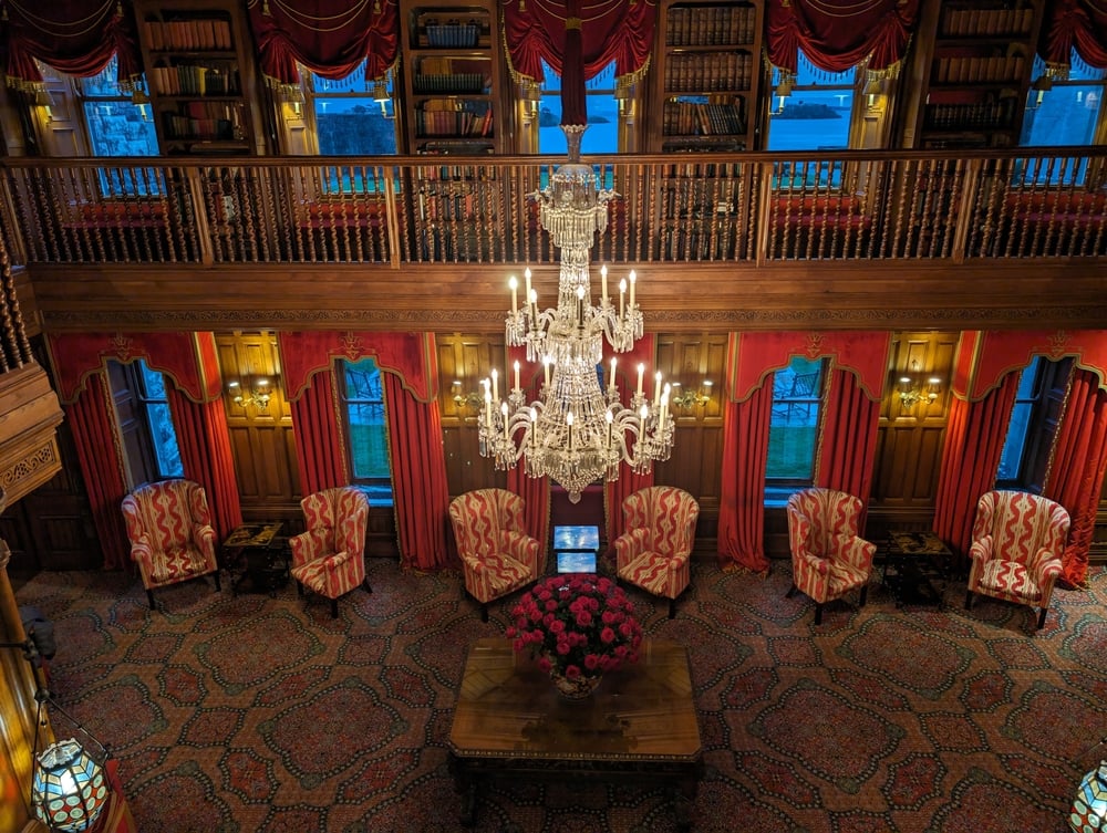 Luxurious lounge at Ashford Castle in Ireland with chandelier and red drap.