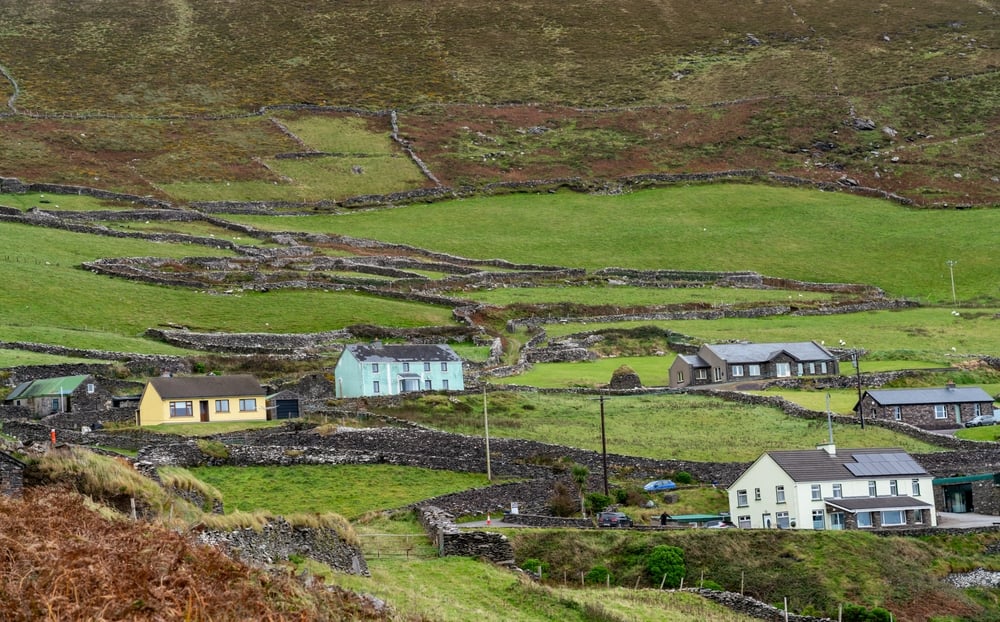 Irish village with colorful houses and terraced fields in Ireland.