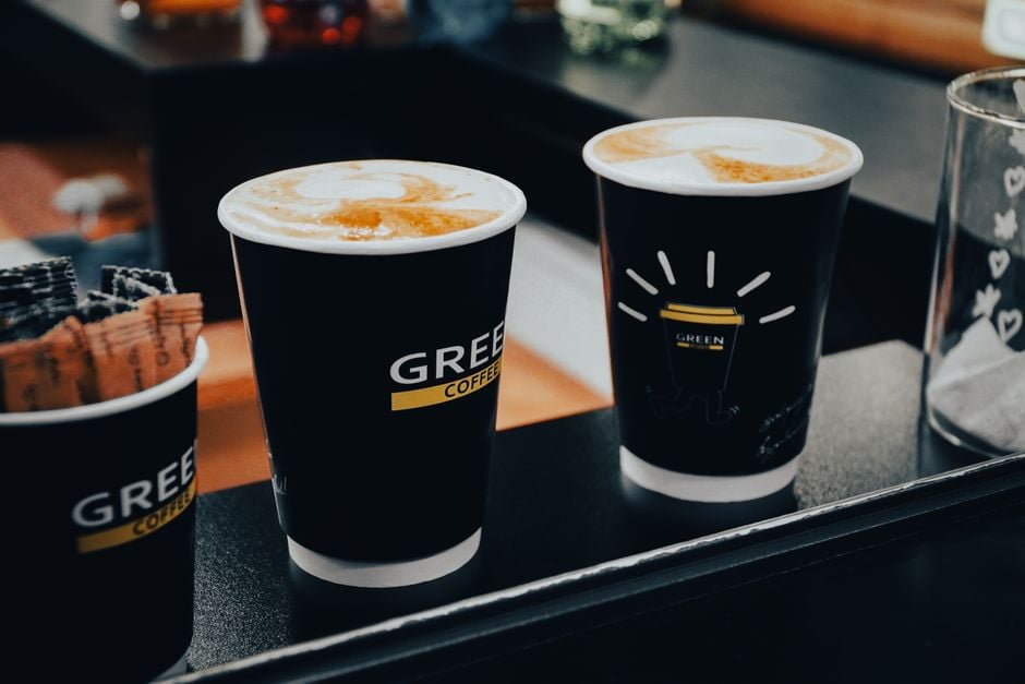Close-up of three coffee cups with latte art at a café, showcasing a warm atmosphere.