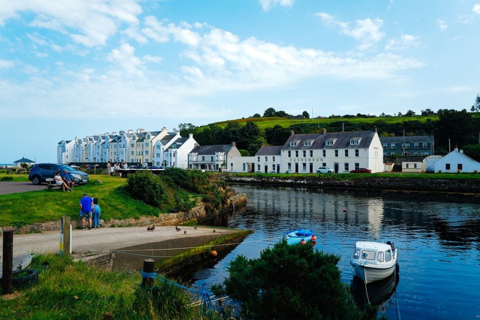 Irish coastal village with colorful houses and boats by the water.