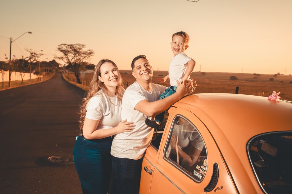 Family with child on car in Irish countryside at sunset.