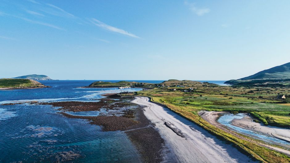 Breathtaking aerial photograph of the scenic coastline in County Kerry, Ireland, capturing clear blue waters and lush green landscapes.