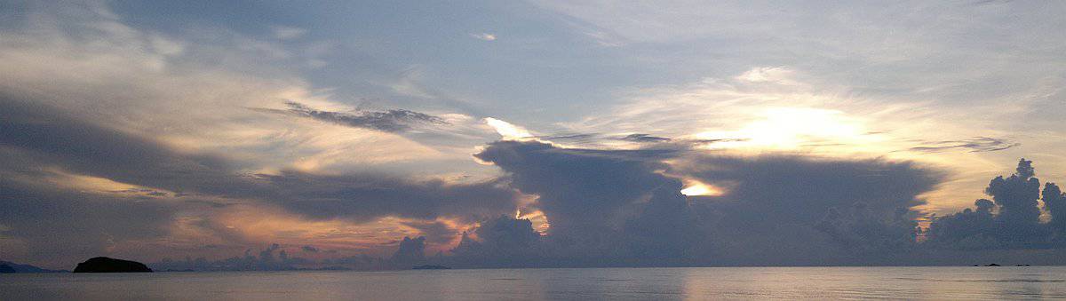Experience a serene ocean sunset aboard our boat tour, as dramatic clouds cast calming reflections on the water.