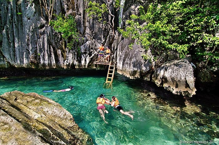 Twin lagoons coron couple floating in one of the lagoons below a ladder