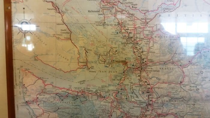 A vintage map perfect for a road trip, showcasing detailed roads and towns of northwestern Washington State, including the San Juan Islands and Skagit. Red lines outline routes for tour enthusiasts, with labels for geographic features and locations in faded ink.