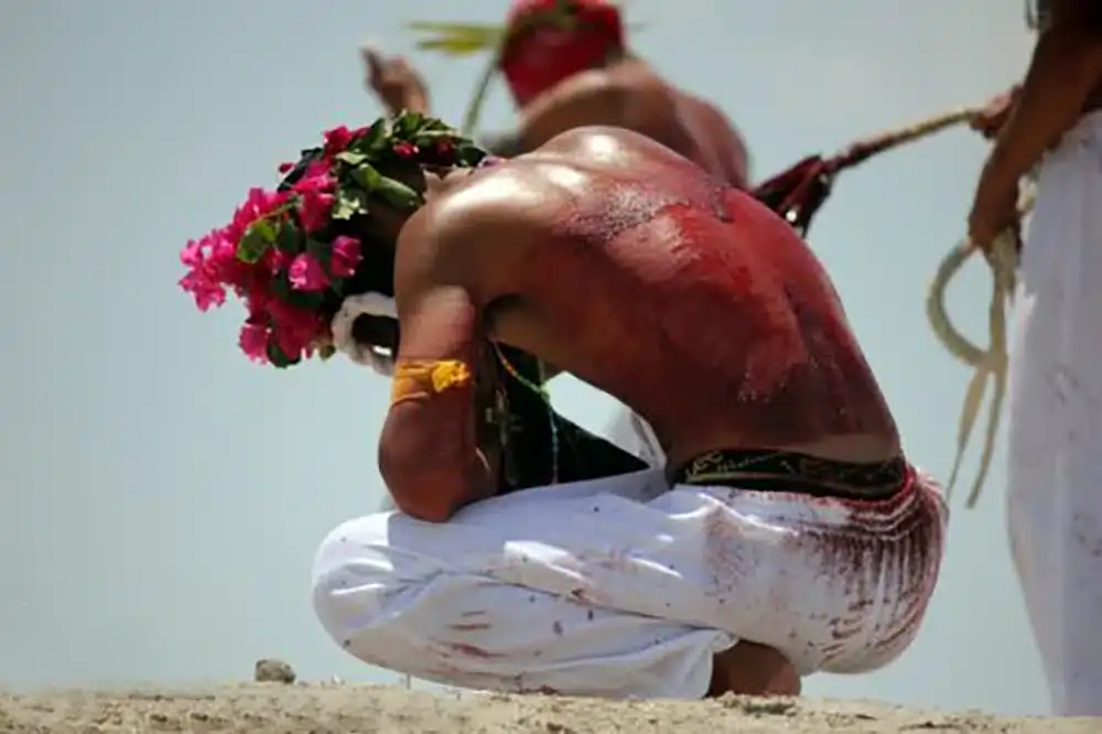 self flagellation philippines religious festivals Vibrant Filipino tribal dancer with traditional attire and flower headdress during a cultural performance.