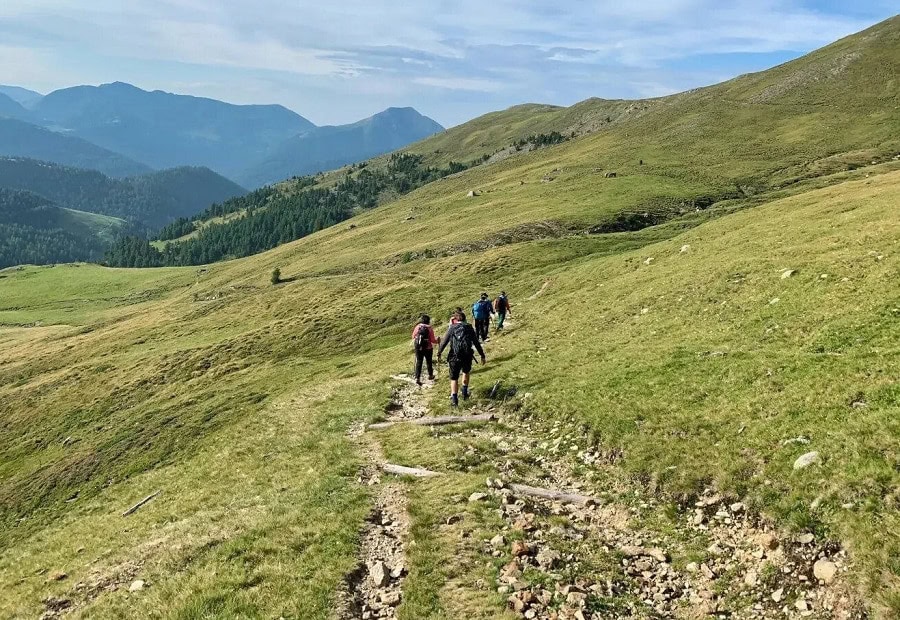 Group of hikers trekking through green mountain trail in the Philippines.