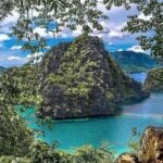 Beautiful coastal landscape of the Philippines with clear blue waters and tropical foliage.