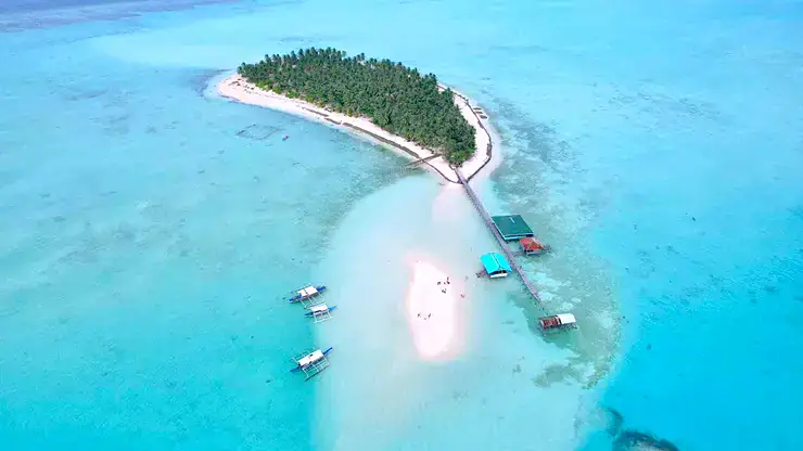 Beautiful Philippine island connected by a pier with lush greenery and turquoise waters.