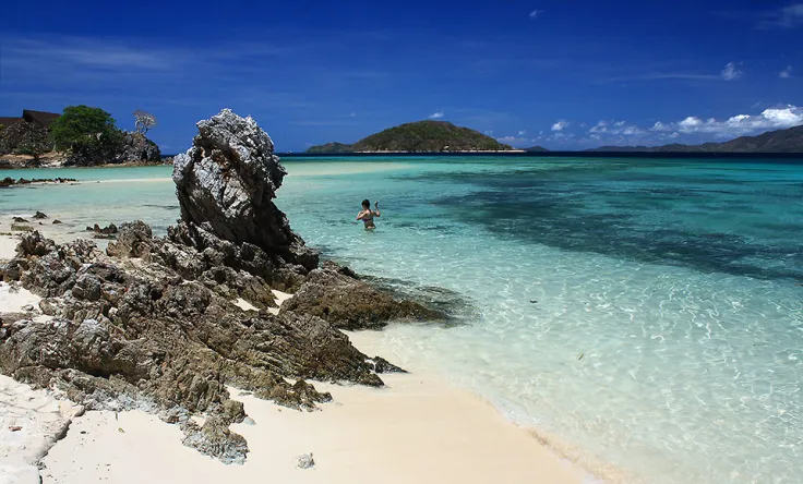 Pristine turquoise waters with rocky shoreline in the Philippines.