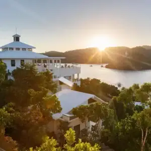 A scenic view of the Philippine coastline with lush greenery and a beautiful sunset over the water.