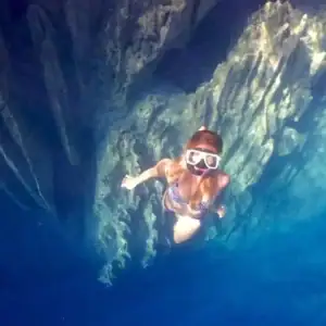 Stunning woman snorkeling in crystal-clear waters inside a scenic Philippine cave.