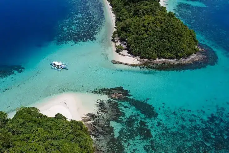 A stunning aerial view of a tropical island with clear turquoise waters and lush green surroundings.