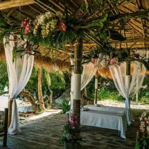 Idyllic tropical gazebo with floral decor overlooking the sea.